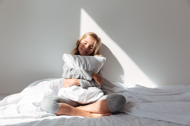 Foto gratuito retrato de una niña sonriente abrazando la almohada