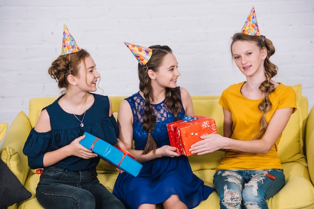 Retrato de niña sonriente cumpleaños tomando regalos de amigos