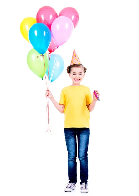 Retrato de niña sonriente feliz en camiseta amarilla con globos de colores - aislados en un blanco.