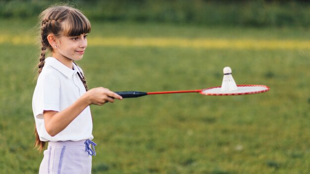 Retrato de una niña sonriente jugando con bádminton