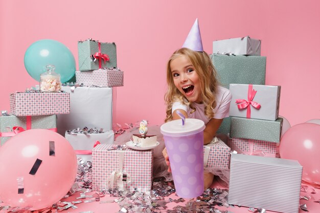 Retrato de una niña sonriente en un sombrero de cumpleaños celebrando