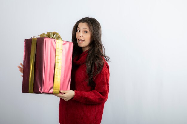 Retrato de una niña sonriente en suéter con caja actual.