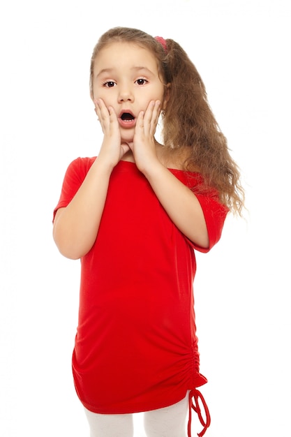 Retrato de una niña sorprendida bonita en vestido rojo aislado en blanco