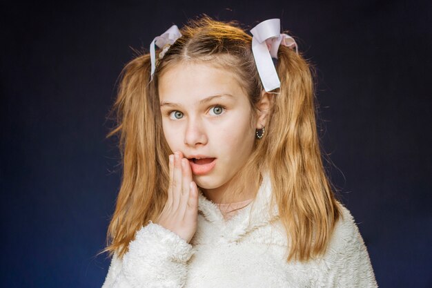 Retrato de una niña sorprendida sobre fondo negro