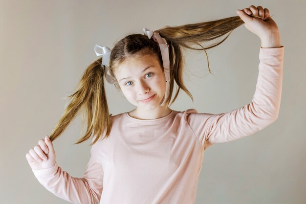 Retrato de una niña sosteniendo su cabello