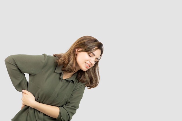 Foto gratuita retrato de niña en traje casual sintiendo dolor en la cintura. foto de alta calidad