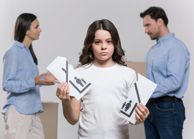 Retrato de niña triste con padres discutiendo detrás