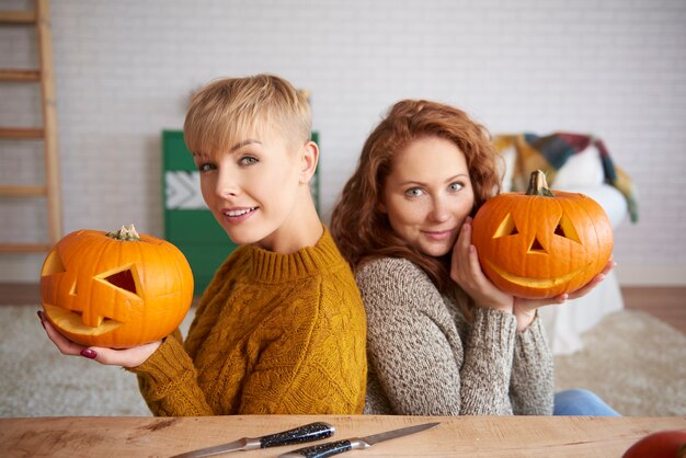 Retrato de niñas felices sosteniendo calabazas