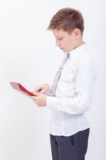 Retrato de niño adolescente con calculadora en blanco