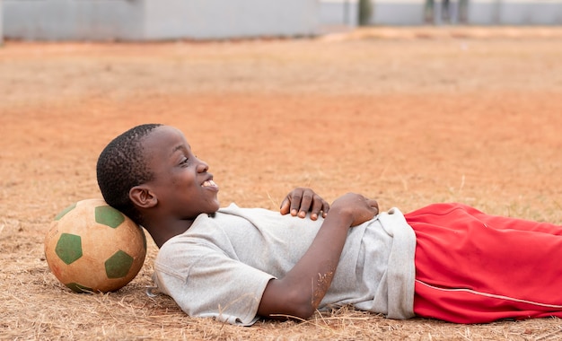 Foto gratuita retrato, niño africano, con, pelota del fútbol