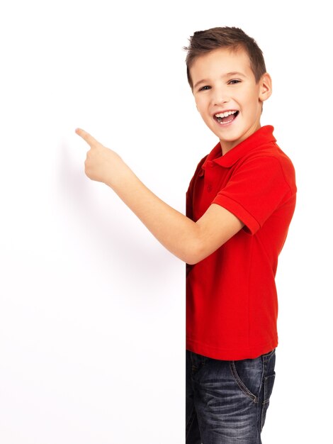 Retrato de niño alegre apuntando en banner blanco - aislado