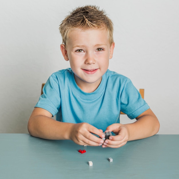 Retrato de niño de cabello rubio con lego