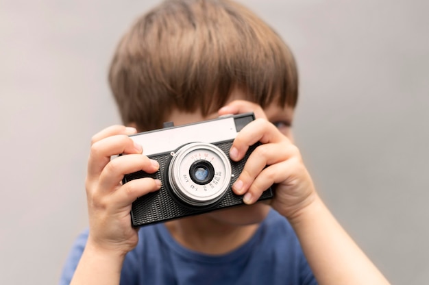 Foto gratuita retrato de niño con cámara