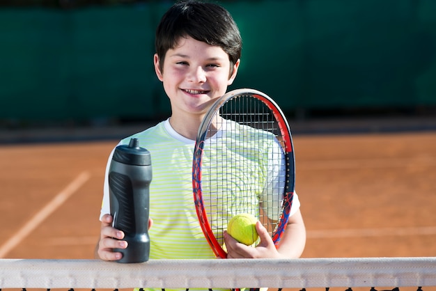 Retrato de niño en el campo de tenis