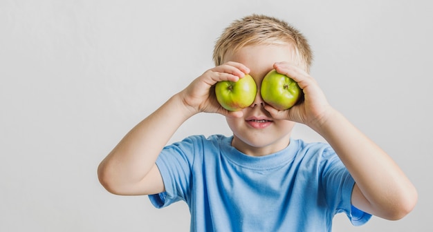 Retrato de niño divertido con manzanas