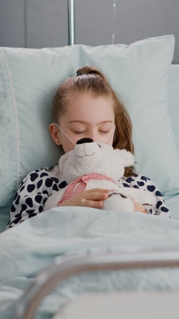 Retrato de niño enfermo cansado durmiendo después de sufrir una cirugía de recuperación médica