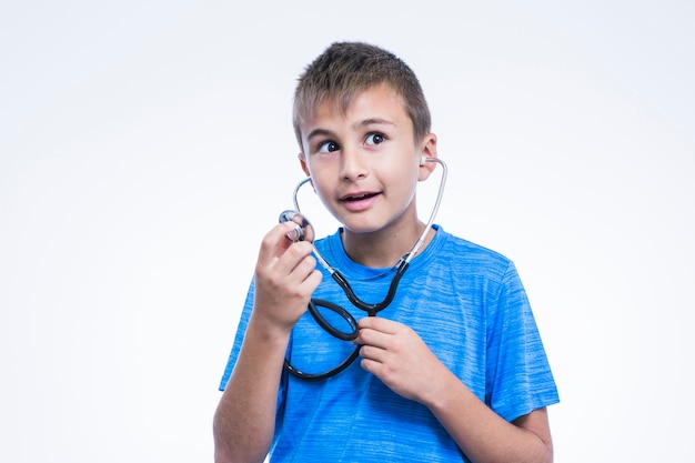 Retrato de un niño con estetoscopio sobre fondo blanco