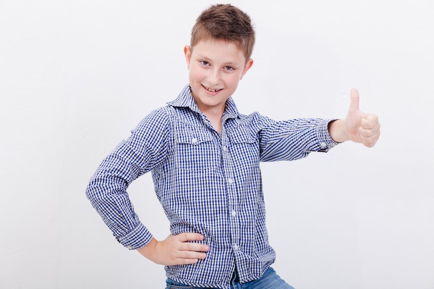 Retrato de niño feliz mostrando pulgar arriba gesto