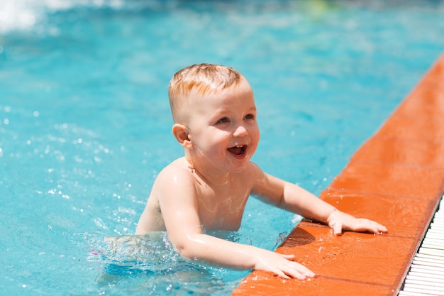 Retrato de niño feliz nadando en la piscina