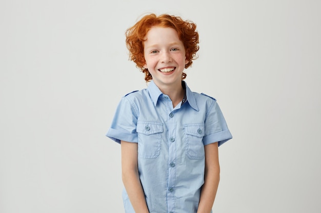 Retrato de niño gracioso con pelo rojo y pecas sonriendo