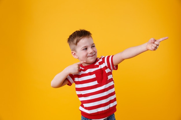 Retrato de un niño gracioso señalando con el dedo