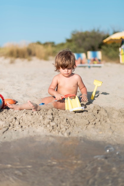 Retrato de un niño haciendo un castillo de arena