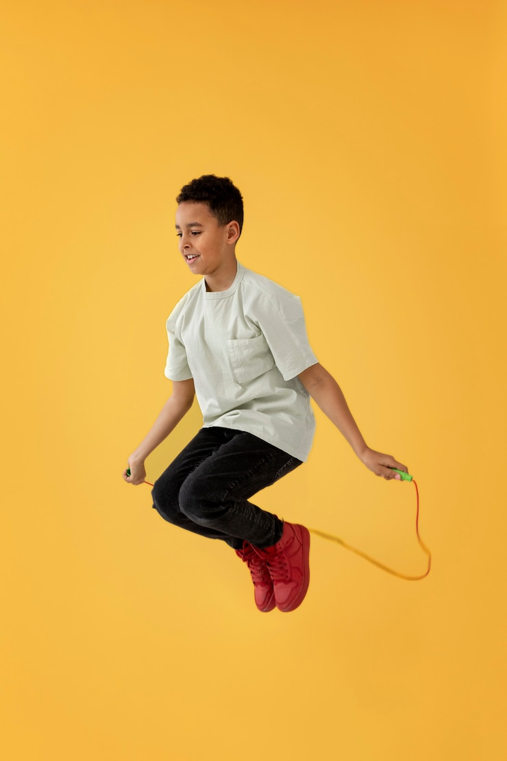 Foto gratuito retrato, de, niño joven, saltar la cuerda