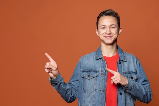 Foto gratuita retrato, de, un, niño joven, señalar, en, algo