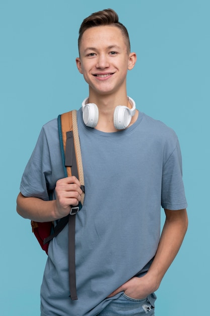 Foto gratuita retrato, de, un, niño joven, tenencia, el suyo, mochila, y, el suyo, auriculares