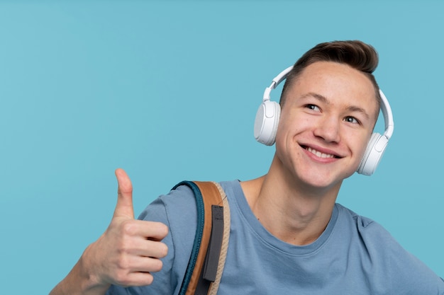 retrato, de, un, niño joven, tenencia, el suyo, mochila, y, utilizar, el suyo, auriculares