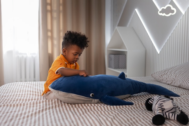 Foto gratuita retrato de niño jugando con su juguete de peluche