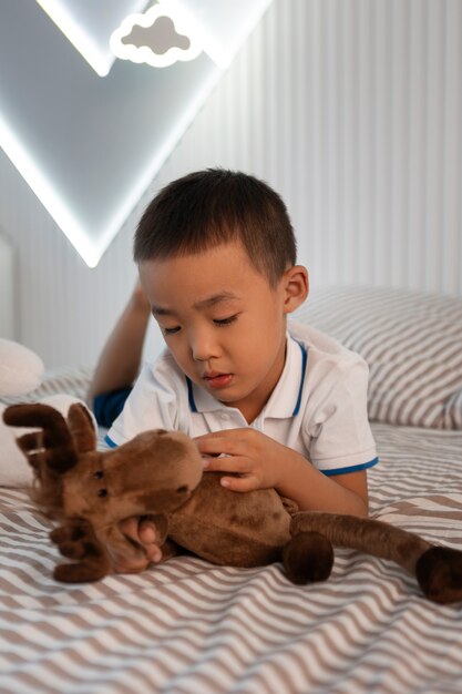 Retrato de niño jugando con su juguete de peluche