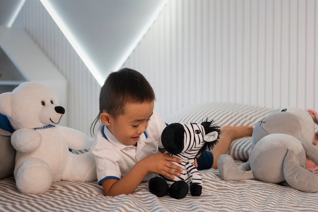 Foto gratuita retrato de niño jugando con su juguete de peluche