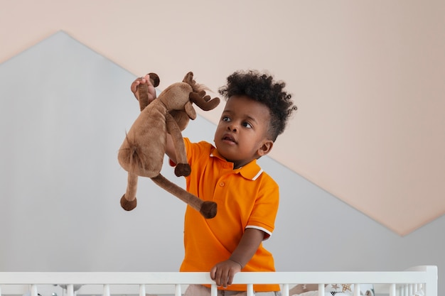Retrato de niño jugando con su juguete de peluche