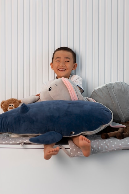 Foto gratuita retrato de niño jugando con su juguete de peluche