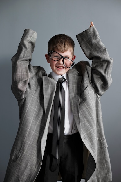 Retrato de niño lindo con traje y gafas de gran tamaño