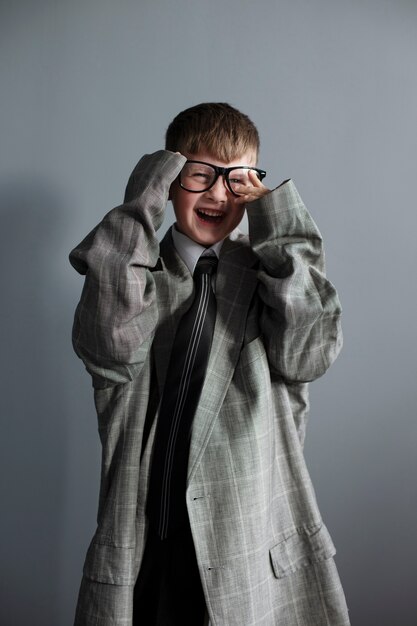 Retrato de niño lindo con traje y gafas de gran tamaño