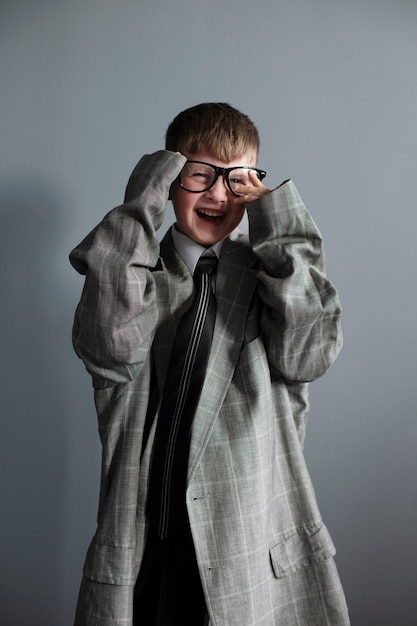 Retrato de niño lindo con traje y gafas de gran tamaño