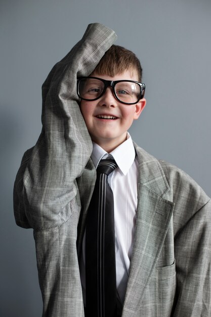 Retrato de niño lindo con traje y gafas de gran tamaño