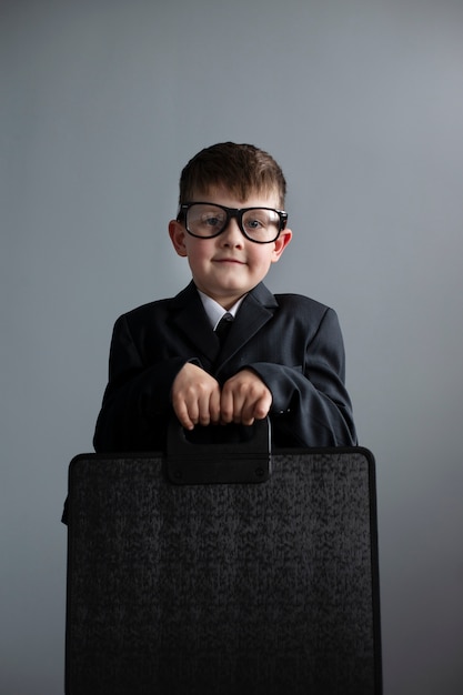 Retrato de niño lindo con traje y maletín