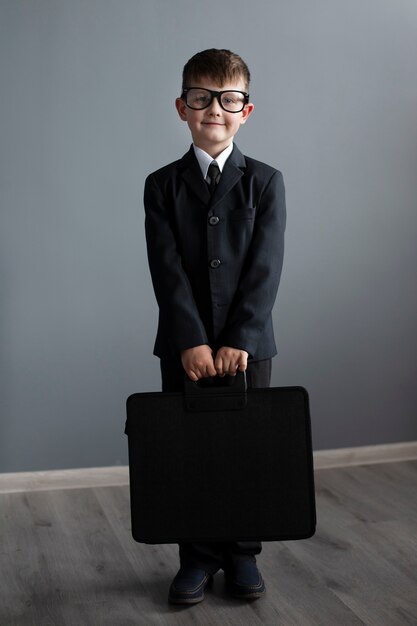 Retrato de niño lindo con traje y maletín