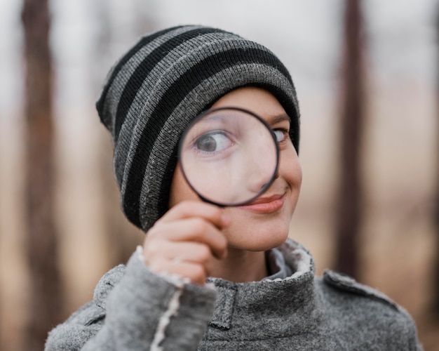 Retrato de niño mirando a través de una lupa fuera