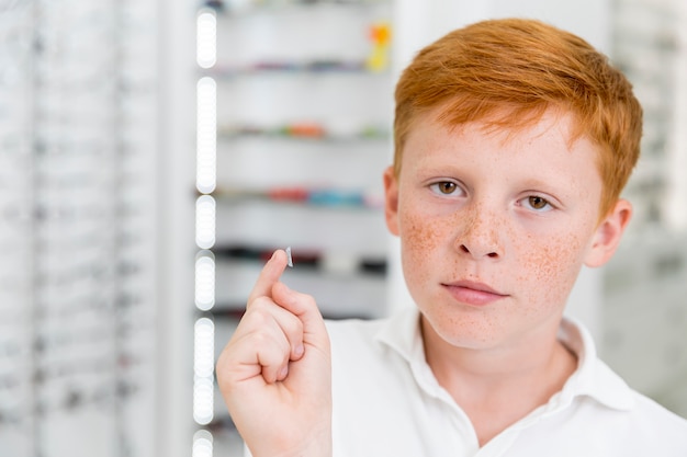 Retrato de niño con pecas con lentes de contacto en clínica de óptica