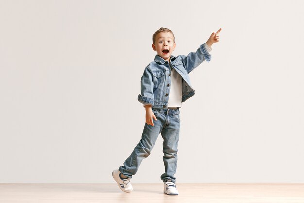 El retrato del niño pequeño lindo en ropa de jeans con estilo