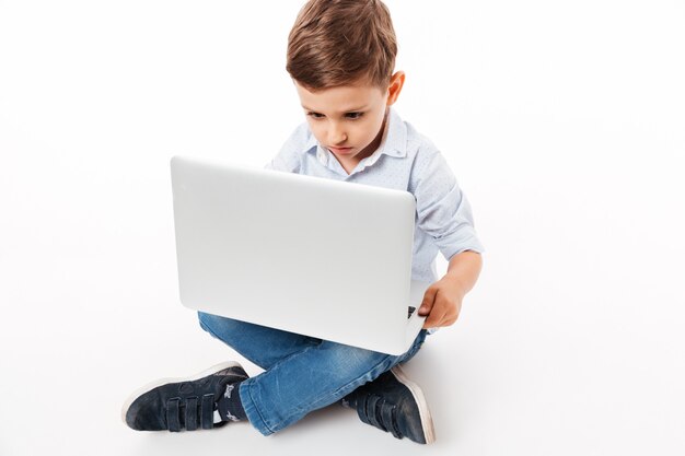 Retrato de un niño pequeño lindo usando la computadora portátil