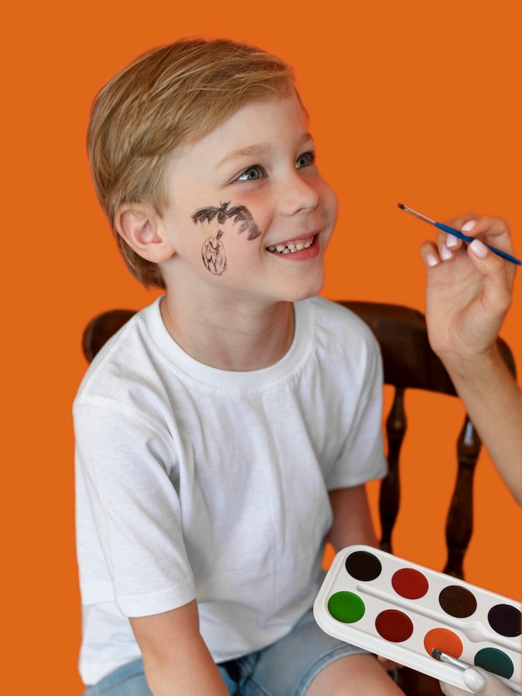 Foto gratuito retrato de niño sonriente con cara pintada para halloween