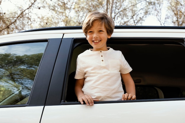 Retrato, niño sonriente, en coche