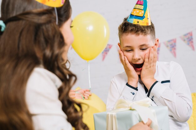 Retrato de un niño se sorprende después de recibir una caja de regalo de su amiga