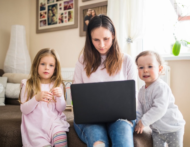 Retrato de un niño con su madre trabajando en la computadora portátil