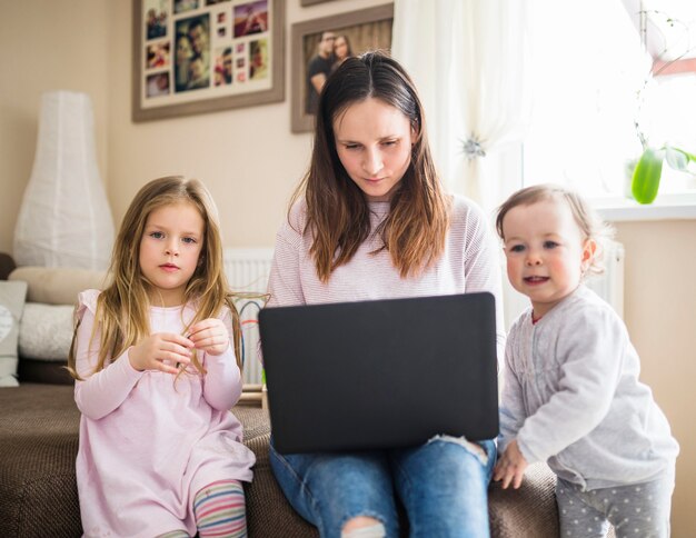 Retrato de un niño con su madre trabajando en la computadora portátil